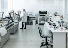 Researchers in lab coats performing experiments with advanced equipment in a laboratory.